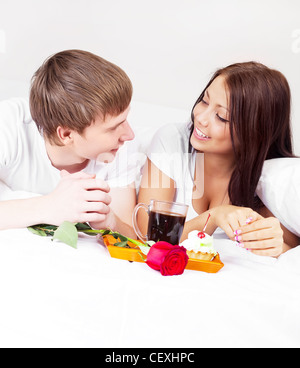 Happy young couple having breakfast in bed Banque D'Images
