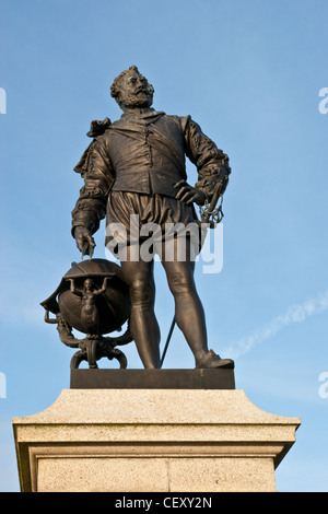 Un plan vertical d'une statue en bronze de Sir Francis Drake, debout sur un socle, donnant sur la mer. Banque D'Images