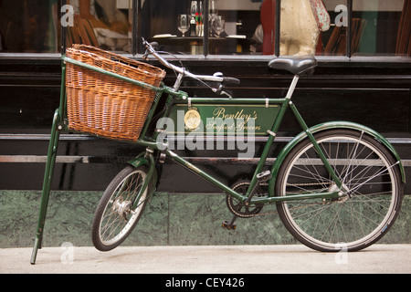 Vue d'un vieux vélo traditionnel avec un panier en osier à l'extérieur de la mer restaurant épiciers Bentley Banque D'Images