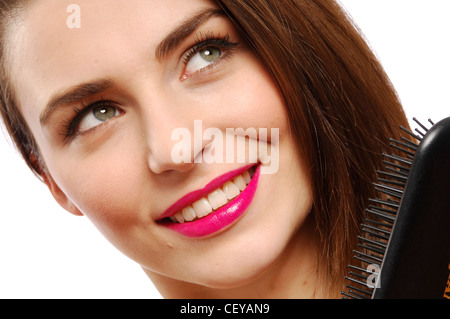 Portrait de femme portant des lèvres rose vif et noir robe satin longue ligne droite de brossage de cheveux brune à la brosse jusqu'à Banque D'Images