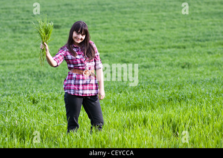 Portrait de la belle jeune femme au champ vert. Focus artistique. Banque D'Images