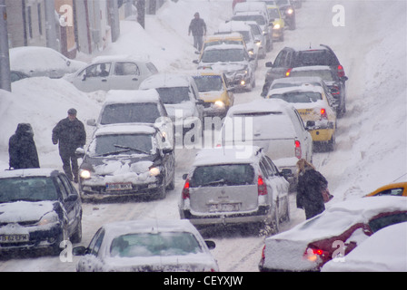 Les voitures et les piétons lutte sur les routes dans des conditions de blizzard. Banque D'Images