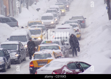 Les voitures et les piétons lutte sur les routes dans des conditions de blizzard. Banque D'Images