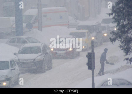 Voitures pris dans un blizzard au cours de froid en Europe de l'Est, février 2012. Des gens luttaient pour obtenir leur voiture décolle. Banque D'Images