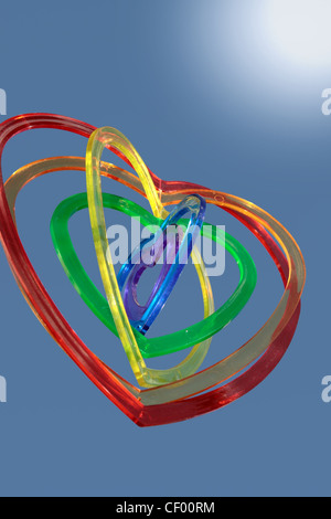 Six pièces en plastique en forme de coeur l'un dans l'autre sous le soleil d'arrière-plan comme si flottant sur l'air Banque D'Images