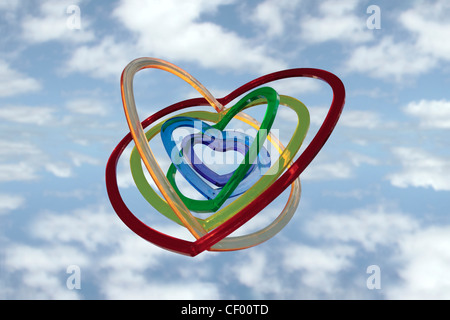 Six pièces en plastique en forme de coeur l'un dans l'autre sur un fond nuageux flottant sur l'air comme si Banque D'Images