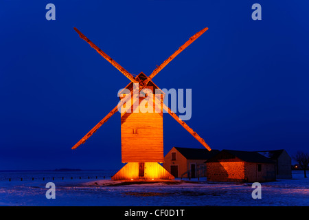 Image de nuit un vieux moulin à vent en bois traditionnel dans un domaine couvert par la neige. Banque D'Images