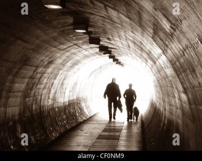 Deux personnes et un chien marchant à travers un tunnel à Latchford (off Kingsway), Warrington, Cheshire, Angleterre, Royaume-Uni Banque D'Images