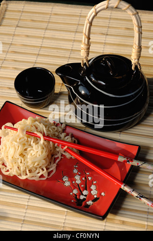 Nouilles Ramen sur plaque décorative de style asiatique, sur bambou, napperon avec des baguettes. Banque D'Images