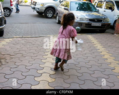 Une fille jouant sur les rues de Mumbai, Maharashtra, Inde Banque D'Images