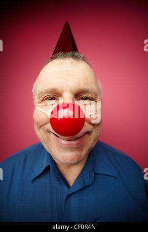 Portrait d'un homme gai avec nez rouge smiling at camera sur fool's day Banque D'Images