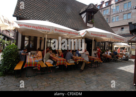 Les visiteurs qui déjeunent au restaurant Bratwurstglocklein dans le village médiéval du Handwerkerhof (cour de Craftmen) à Nuremberg, en Bavière, Banque D'Images