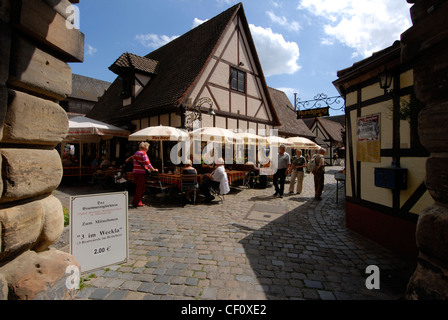 Les visiteurs déjeunent au restaurant Bratwurstglocklein, dans le village médiéval du Handwerkerhof (cour des commerçants) à Nuremberg, en Bavière Banque D'Images