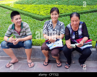 Jeune homme avec deux femmes les vendeurs de rue, Hanoi, Vietnam Banque D'Images