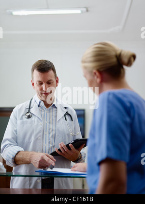 Médecin parler aux jeunes femmes à travailler comme infirmière dans une clinique médicale et dossier médical. Banque D'Images