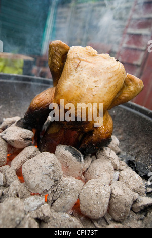 Un poulet rôti lentement sur un barbecue Banque D'Images