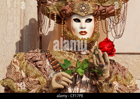 Femme masquée avec une rose rouge au Carnaval de Venise, Italie Banque D'Images