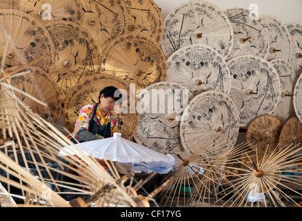 Femme faisant des parasols en bambou et en papier en Thaïlande Banque D'Images