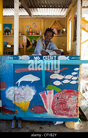 Un résident local et gérant d'un bar de plage attend les clients à Chatham Bay sur l'île de l'Union européenne. Banque D'Images