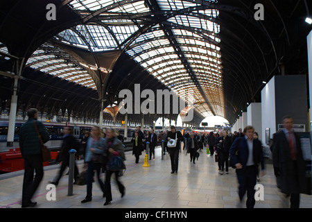 Au début de l'heure de pointe comme les navetteurs à pied le long d'une plate-forme vers la sortie de la gare de Paddington à Londres. Banque D'Images