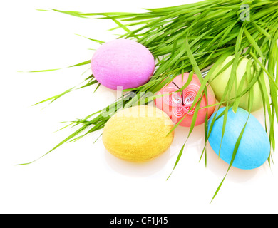 Oeufs colorés de Pâques avec l'herbe isolé sur fond blanc Banque D'Images