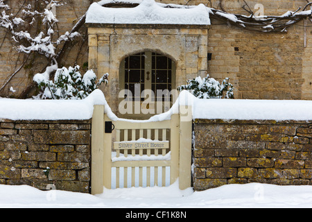 Porte couvert de neige et le chemin menant à la porte avant de Silver Street, maison en pierre d'un village de Cotswold House dans le sud de cerne Banque D'Images