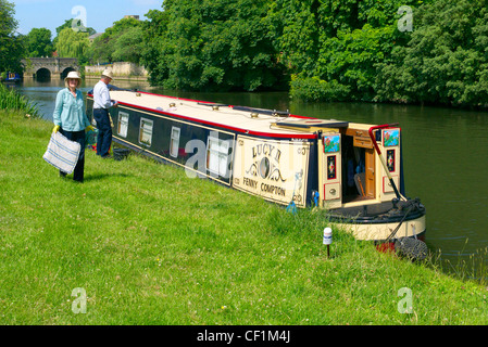 Un couple de personnes âgées à travailler sur leur yacht amarré sur la Tamise à Abingdon. Banque D'Images