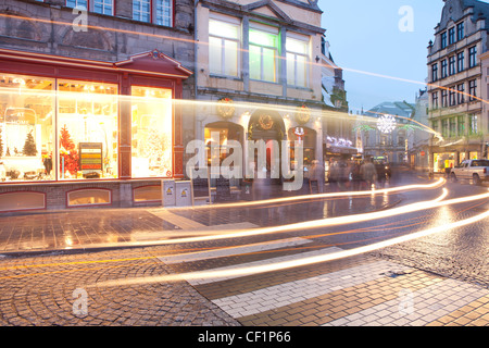 Vue en légèreté le long d'une rue pavée traditionnelle à Noël à Bruges Banque D'Images