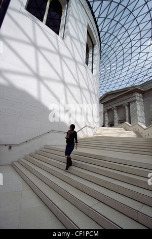 Une femme walking down steps de l'original du British Museum Salle de lecture dans le centre de la Queen Elizabeth II Great Court Banque D'Images