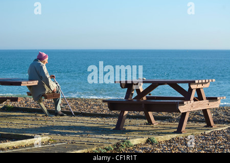 Femme âgée assis face à la mer Hayling Island Hampshire UK Banque D'Images