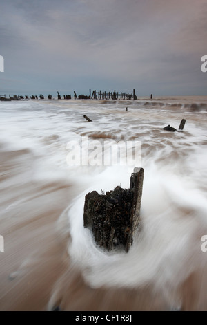 Vagues roulant sur la plage à Happisburgh sur la côte de Norfolk. Banque D'Images