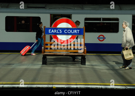 Les passagers marchant le long d'une plate-forme à la station de métro Earl's Court. Banque D'Images