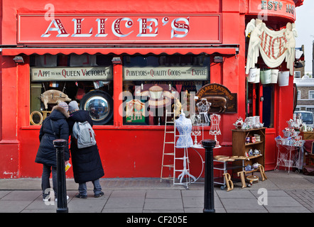 Deux femmes parcourant la fenêtre d'Alice's, une boutique d'antiquités de Portobello Road. Banque D'Images