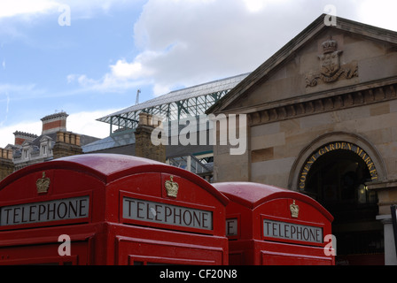 Deux cabines téléphoniques traditionnels K6 près de l'entrée de marché couvert de Covent Garden. Banque D'Images