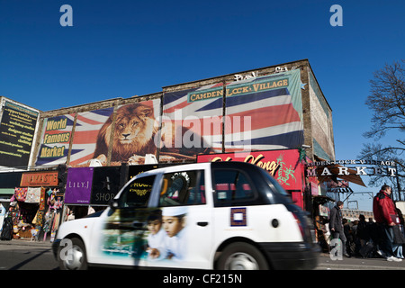 Un taxi de Londres en passant une entrée de Camden Lock Village Market. Banque D'Images