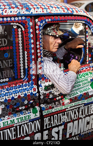 Un chauffeur de taxi à un Pearly Kings and Queens décoré Londres taxi. Banque D'Images