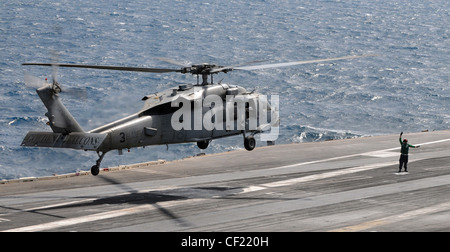 MER D'ARABIE (fév 26, 2012) un hélicoptère MH-60S Sea Hawk affecté aux Faucons d'or de l'Escadron de combat de la mer (HSC) 12 se prépare à atterrir sur le pont de vol du porte-avions USS Abraham Lincoln de la classe Nimitz (CVN 72). Abraham Lincoln est déployé dans la zone de responsabilité de la 5e flotte américaine, en effectuant des opérations de sécurité maritime, des efforts de coopération en matière de sécurité dans les théâtres et des missions de soutien dans le cadre de l'opération Enduring Freedom. Banque D'Images