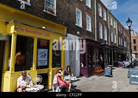 Les personnes mangeant à l'extérieur des cafés à Camden Passage. Banque D'Images