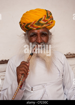 L'homme hindou turban jaune portant des fumeurs au Rajasthan, Inde Banque D'Images