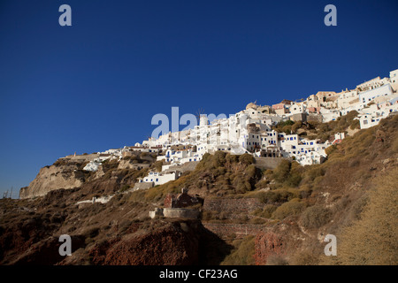 Vue à la recherche vers le village grec traditionnel d''Oia perché sur les falaises au-dessus de la Caldera de Santorin Banque D'Images