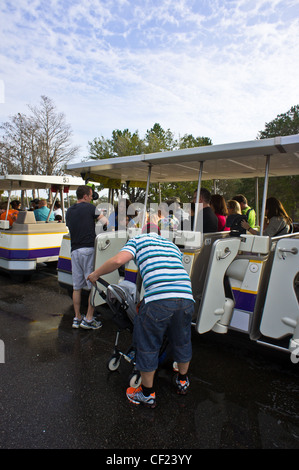 Les visiteurs d'entreprendre un tramway desservant les terrains de stationnement dans un parc Disney World, en Floride, Février 2012 Banque D'Images