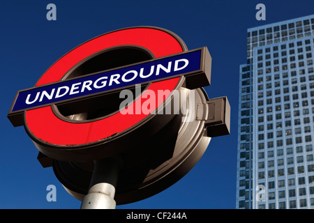 London Underground sign et One Canada Square, le deuxième plus haut édifice de l'UK. Banque D'Images