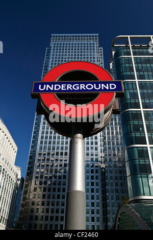 London Underground sign et One Canada Square, le deuxième plus haut édifice de l'UK. Banque D'Images