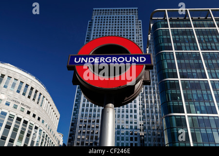 London Underground sign et One Canada Square, le deuxième plus haut édifice de l'UK. Banque D'Images