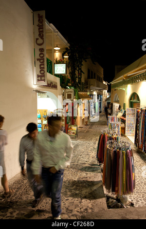 Les touristes en se promenant dans les petites rues du village de Thira dans la nuit Banque D'Images