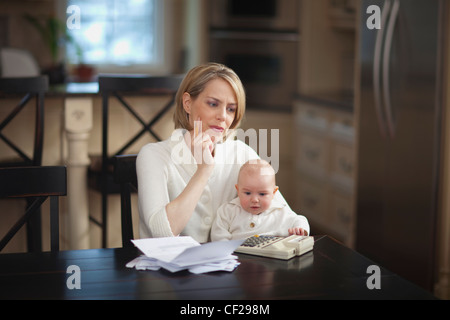 Mère avec bébé soulignant sur les finances des ménages ; Jordan Ontario Canada Banque D'Images