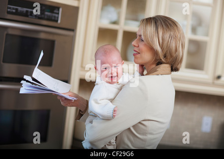 Mère avec bébé soulignant Plus de factures du ménage ; Jordan Ontario Canada Banque D'Images