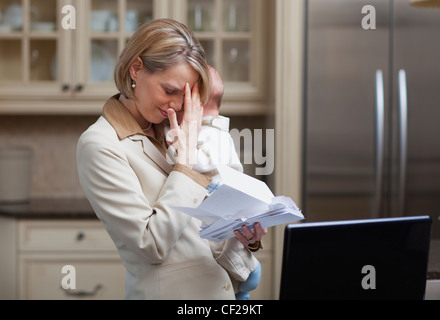 Mère avec bébé soulignant Plus de factures du ménage ; Jordan Ontario Canada Banque D'Images