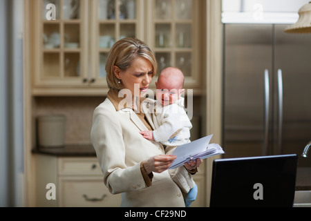 Mère avec bébé soulignant Plus de factures du ménage ; Jordan Ontario Canada Banque D'Images