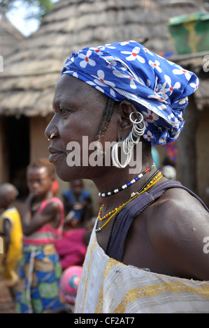 Les Bedik femme aux boucles d'oreilles et de son nez à travers la bobine de Porcupine dans village Iwol, Bassari, district de Kédougou, Sénégal région Banque D'Images